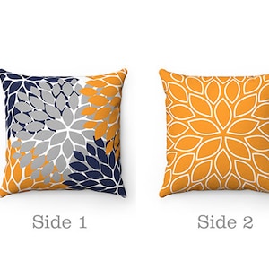 May include: Two-sided throw pillow with a floral pattern. One side features a grey, navy blue, and yellow floral design. The other side features a yellow floral design with white outlines.