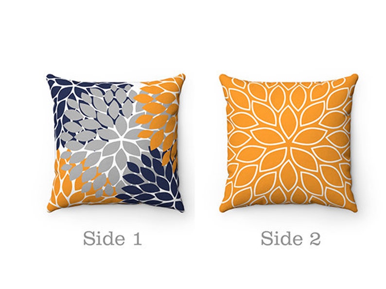 May include: Two-sided throw pillow with a floral pattern. One side features a grey, navy blue, and yellow floral design. The other side features a yellow floral design with white outlines.
