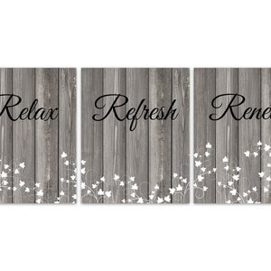 May include: Three wood-grain panels with white floral designs and the words "Relax", "Refresh", and "Renew" in black lettering.