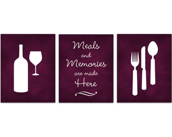 May include: Three framed wall art pieces with white silhouettes on a dark burgundy background. The images include a wine bottle and glass, the text "Meals and Memories are made Here", and silverware.