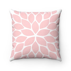 May include: A pink and white throw pillow with a floral pattern. The pillow is made of soft fabric and has a square shape.