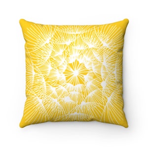 May include: A yellow throw pillow with a white dandelion design. The pillow is square and has a soft, plush texture.