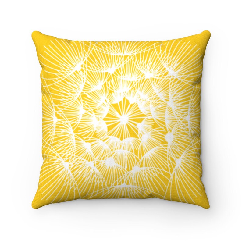 May include: A yellow throw pillow with a white dandelion design. The pillow is square and has a soft, plush texture.