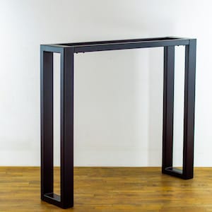 Op de afbeelding: Zwarte metalen consoletafel met een rechthoekig blad en een eenvoudig, modern ontwerp.