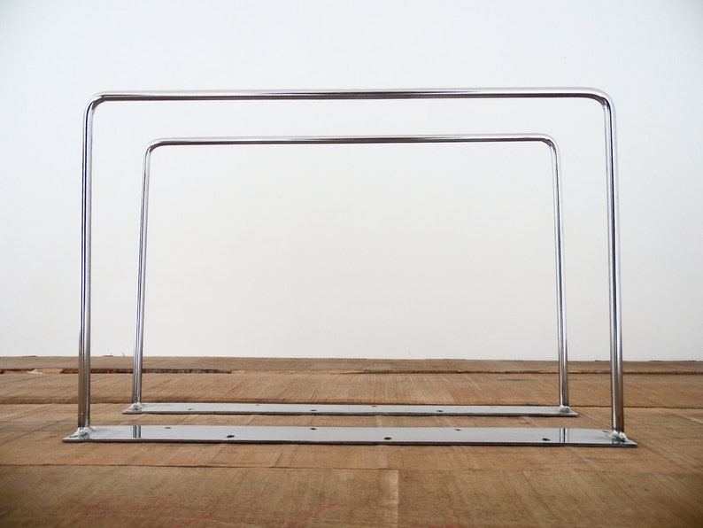May include: Two chrome hairpin legs with a flat base. The legs are made of metal and have a polished chrome finish.