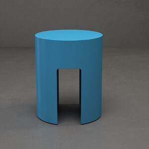 A turquoise cylinder side table made of metal , has a gap on the sides that begin ffom the bottom to the half of the base .it is useful as side table and end table .it has contemporary look