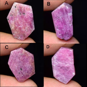 Può includere: Un collage di quattro pietre preziose di rubino grezzo. I rubini sono di un vibrante colore rosa-rossastro, con texture e inclusioni naturali visibili. Ogni pietra ha una forma unica, che mette in risalto la natura grezza e non lucidata delle gemme.
