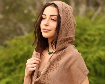 May include: A brown hooded shawl with a geometric pattern. The shawl is made of a soft, natural fabric and has a relaxed, bohemian style.