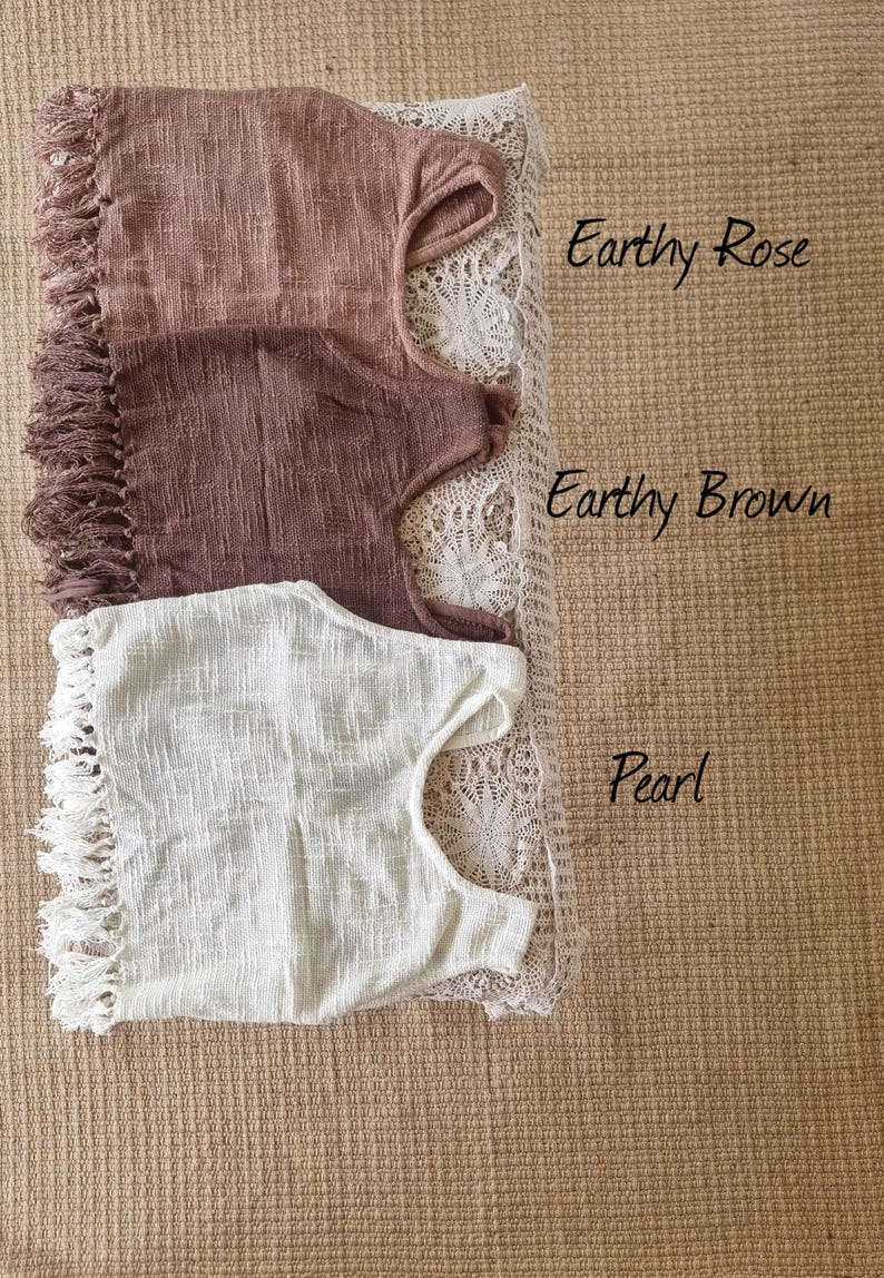 May include: Three crocheted tops with fringe trim. The top on the left is a light brown color, the middle top is a darker brown color, and the top on the right is white. The tops are labeled "Earthy Rose", "Earthy Brown", and "Pearl".