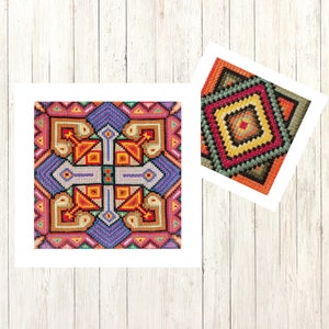 May include: Two colourful cross-stitch patterns are displayed on a light wood background. The larger piece features a central cross design with orange, blue, and yellow geometric shapes. The smaller piece has a diamond pattern with red, green, and orange hues.