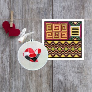 May include: A cross-stitch heart in a round hoop and a geometric design on a square canvas. The heart is red, black, and grey. The square design features yellow, green, and purple geometric patterns. Two red felt hearts and a decorative bird are also present.