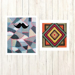 May include: Two framed cross-stitch artworks. One features a black moustache over a geometric pattern in shades of blue, grey, and pink. The other displays a colourful diamond pattern with red, orange, yellow, and green hues.