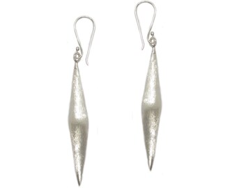 Può includere: Un paio di orecchini d'argento con un design lungo, appuntito e a forma di diamante.