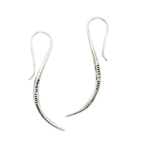 May include: A pair of silver dangle earrings with a curved design and a textured finish.