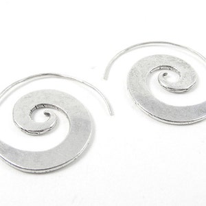 May include: A pair of silver spiral hoop earrings. The earrings are made of metal and have a textured finish.