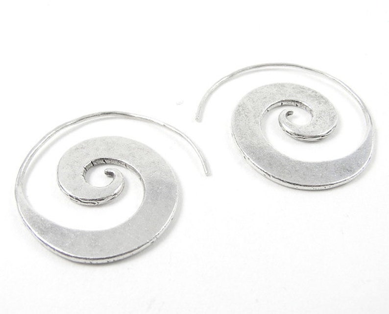 May include: A pair of silver spiral hoop earrings. The earrings are made of metal and have a textured finish.