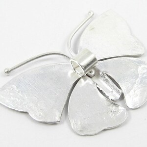 May include: Silver butterfly charm with a textured finish and a jump ring for attaching to jewelry.