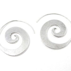May include: A pair of silver spiral hoop earrings. The earrings are made of metal and have a smooth, polished finish.