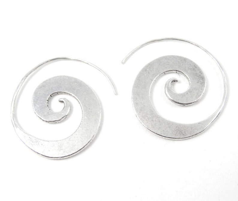 May include: A pair of silver spiral hoop earrings. The earrings are made of metal and have a smooth, polished finish.