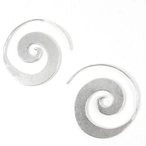 May include: A pair of silver spiral hoop earrings. The earrings are made of a thin metal and have a simple, elegant design.