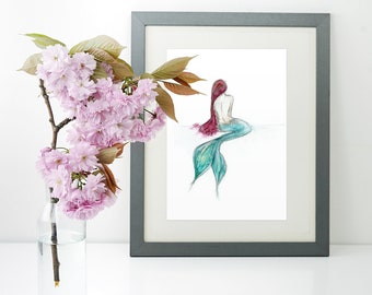 May include: A framed watercolor painting of a mermaid with a teal tail and long red hair. The mermaid is sitting with her back to the viewer. The painting is on a white background and is framed in a gray frame.