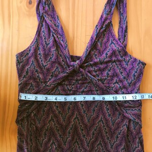 Puede incluir: Vestido morado sin mangas con un estampado de chevr&oacute;n en tonos marr&oacute;n, azul y negro. El vestido presenta un escote en V y un detalle de nudo en el busto. El vestido mide aproximadamente 33 cm de ancho en la cintura.