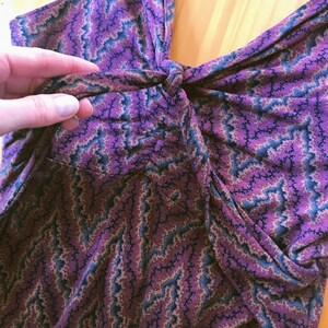 Puede incluir: Un top sin mangas con un estampado de zigzag morado, azul y beige. La tela est&aacute; fruncida en la cintura y anudada en el busto. El top est&aacute; hecho de un material suave y fluido.