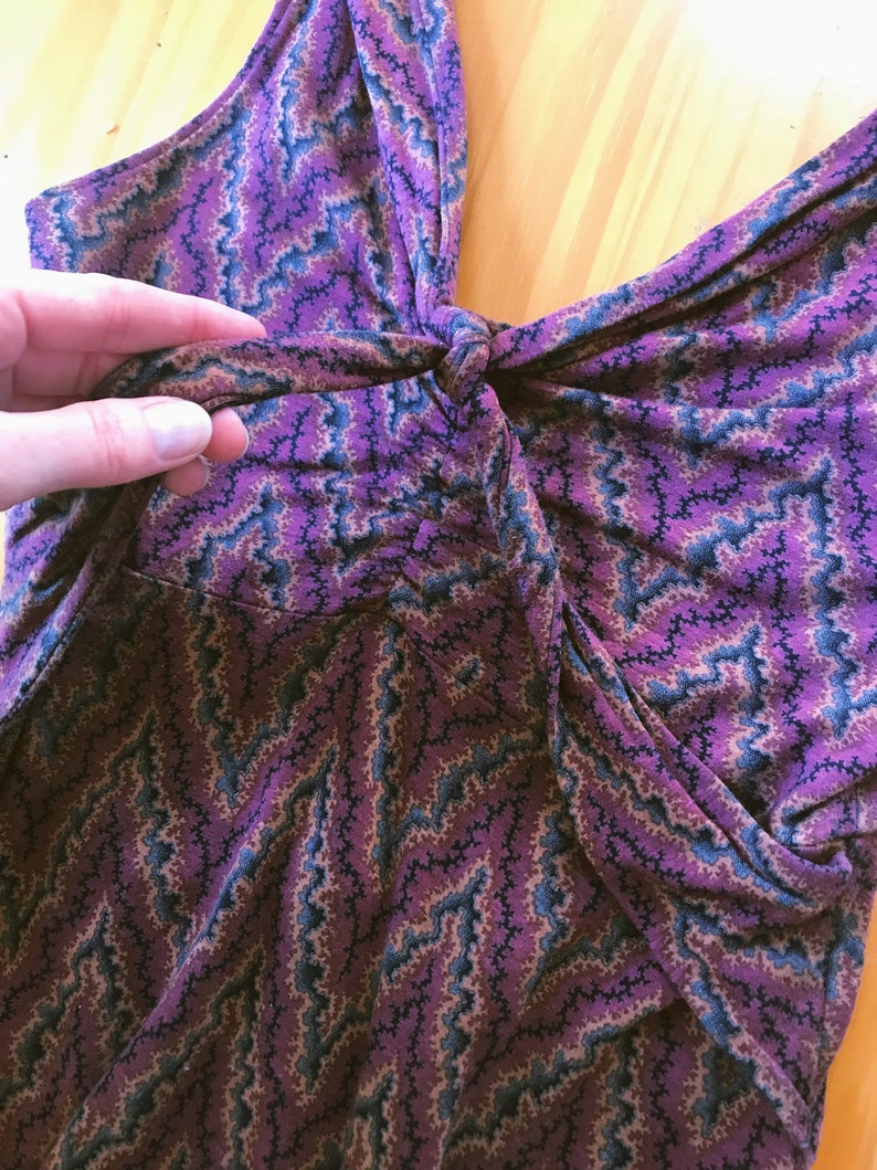 Puede incluir: Un top sin mangas con un estampado de zigzag morado, azul y beige. La tela est&aacute; fruncida en la cintura y anudada en el busto. El top est&aacute; hecho de un material suave y fluido.