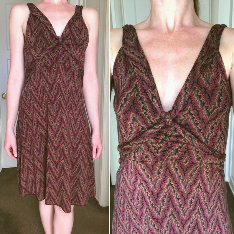 Puede incluir: Vestido sin mangas con escote en V y estampado de zigzag en tonos burdeos, negro y beige. El vestido tiene un corpi&ntilde;o ajustado y una falda acampanada. Las correas son anchas y se cruzan en la espalda.