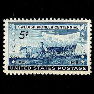 May include: A blue and white United States postage stamp commemorating the Swedish Pioneer Centennial. The stamp features a covered wagon pulled by oxen, with a man walking beside it. The stamp also includes the text "Swedish Pioneer Centennial", "5¢", "1848", and "1948".