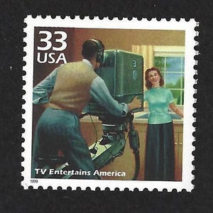May include: A vintage-style 33 cent US postage stamp featuring a black and white image of a television camera operator filming a woman in a living room. The text "TV Entertains America" is printed below the image. The year 1999 is printed in the bottom left corner.