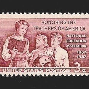 May include: A vintage 3-cent United States postage stamp honoring the teachers of America. The stamp features a red-brown color scheme and depicts three teachers, one holding a book and the other two holding a globe. The stamp also includes the text "HONORING THE TEACHERS OF AMERICA", "NATIONAL EDUCATION ASSOCIATION", "1857 1957", and "UNITED STATES POSTAGE".