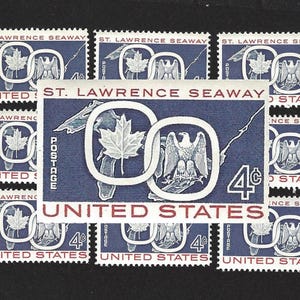 May include: A sheet of nine 4-cent United States postage stamps commemorating the St. Lawrence Seaway. Each stamp features a blue background with a white circle containing a maple leaf and an eagle. The text "ST. LAWRENCE SEAWAY" and "UNITED STATES" is printed in red.