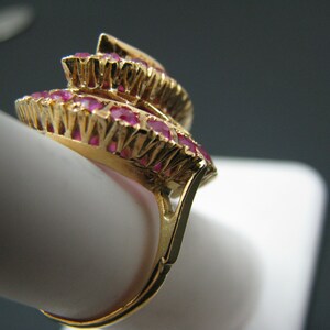 May include: A gold ring with a cluster of red ruby stones set in a layered design.