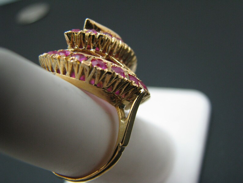 May include: A gold ring with a cluster of red ruby stones set in a layered design.