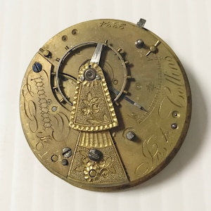 Pu&ograve; includere: Un movimento di orologio da tasca color oro con incisioni intricate e un design floreale. Il quadrante dell'orologio &egrave; contrassegnato dal testo "S.C. London" e "No. 7664".