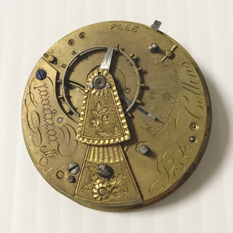 Pu&ograve; includere: Un movimento di orologio da tasca color oro con incisioni intricate e un design floreale. Il quadrante dell'orologio &egrave; contrassegnato dal testo "S.C. London" e "No. 7664".