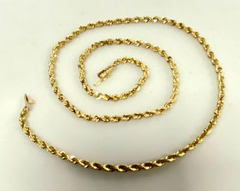 May include: A gold rope chain necklace and bracelet set. The necklace is longer than the bracelet.