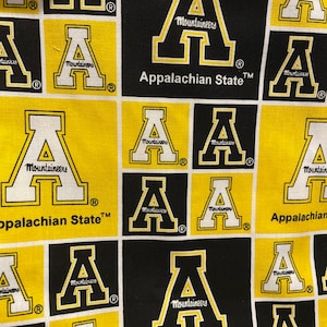 Peut inclure: Un tissu jaune et noir avec un motif répété de la lettre "A" avec les mots "Appalachian State" et "Mountaineers".