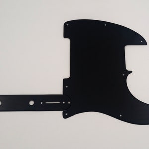 Może przedstawiać: Czarny pickguard do gitary z oddzielną płytką kontrolną. Pickguard ma zaokrąglony kształt i jest wykonany z gładkiego, twardego materiału.