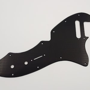 Peut inclure: Une plaque de protection de guitare noire avec plusieurs trous et une découpe pour un micro.