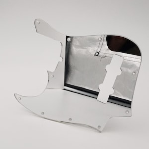 Può includere: Un battipenna per chitarra color argento con finitura a specchio. Il battipenna ha un'apertura per un pickup e una manopola di controllo.