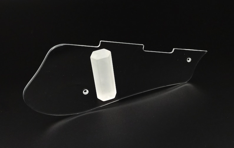 Puede incluir: Un protector de guitarra de pl&aacute;stico transparente con un soporte de p&uacute;a hexagonal blanco.