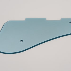 May include: A light blue plastic guitar pickguard with two small holes.