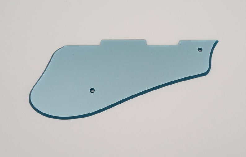 May include: A light blue plastic guitar pickguard with two small holes.