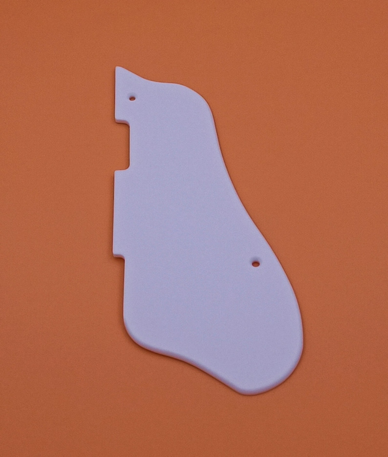 May include: White plastic guitar pickguard with two small holes.