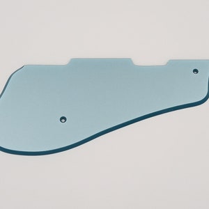 May include: A light blue plastic guitar pickguard with two small holes.