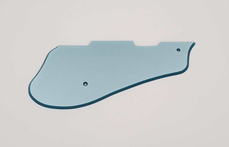 May include: A light blue plastic guitar pickguard with two small holes.