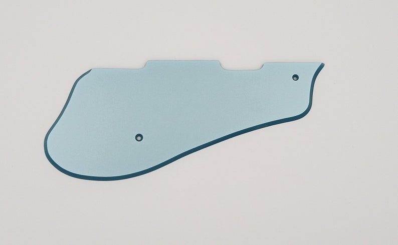 May include: A light blue plastic guitar pickguard with two small holes.