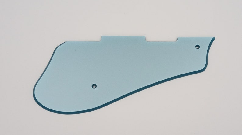 May include: A light blue plastic guitar pickguard with two small holes.